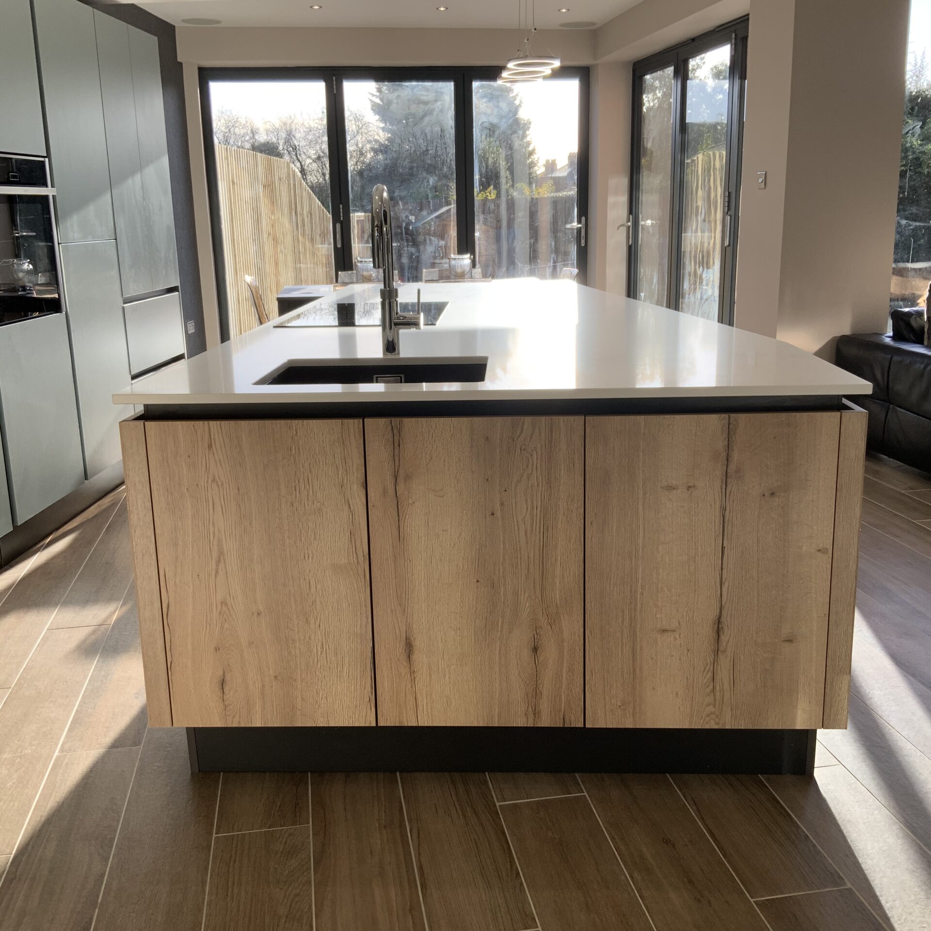 Mid blue and oak effect kitchen in Milton Keynes Large kitchen island in mid blue kitchen