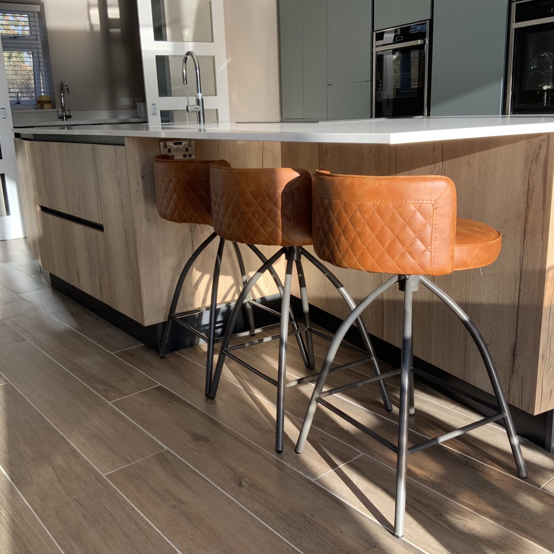 Mid blue oak effect kitchen in Milton Keynes Breakfast bar with 3 tan leather bar stools