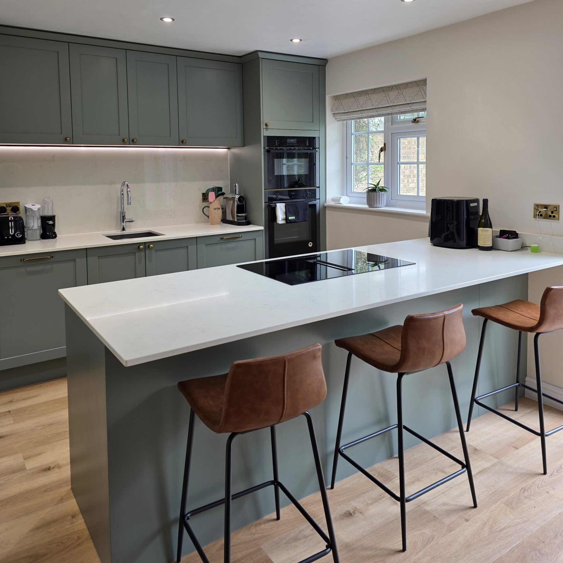 Sage green shaker kitchen in milton keynes with large peninsula and breakfast bar seating Sage green shaker kitchen in Milton Keynes